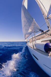 View of the side of a sailing boat while on the ocean.