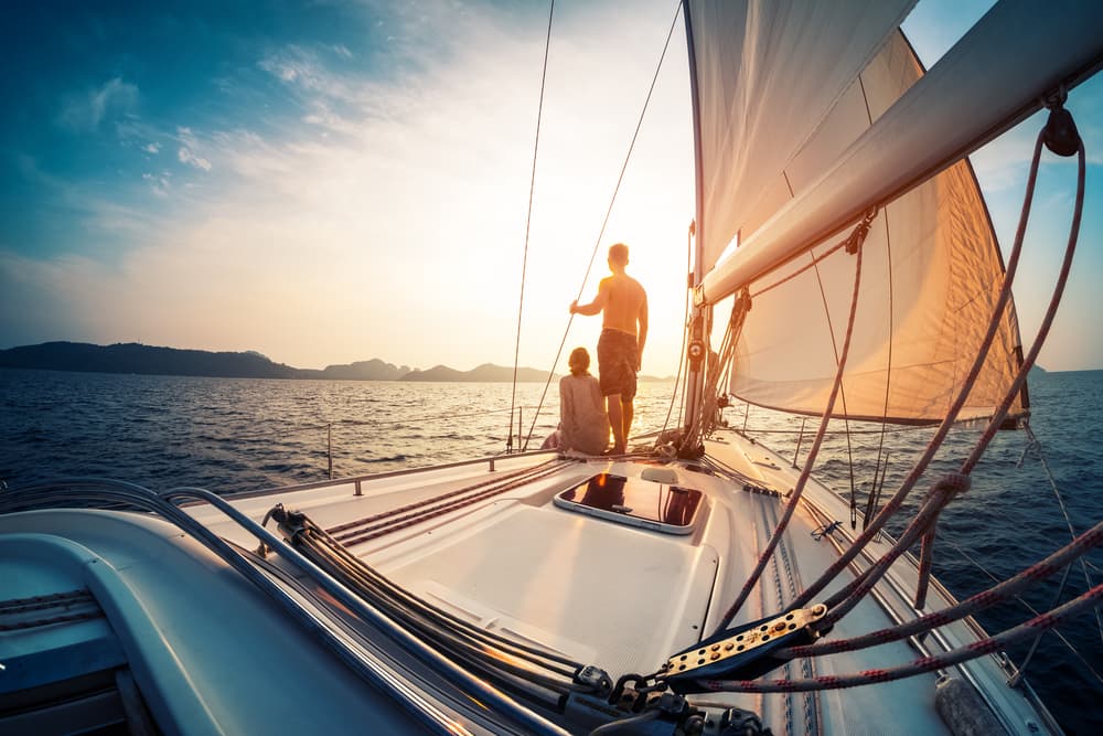 Two people sailing on a yacht with a marine watermaker.